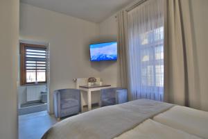 Dormitorio con cama, escritorio y TV en APARTAMENT - ZAKOPIAŃSKI, en Zakopane