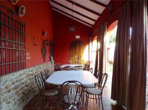 a table and chairs in a restaurant with red walls at Casa D Mis Dos Gitanillas in Córdoba