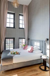 a bedroom with a bed with a tray of food on it at Browar Hevelius Apartments in Gdańsk