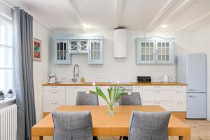 a kitchen with a table with chairs and a vase of flowers at Studio Vintage na Kamiennej Górze in Gdynia +27 photos