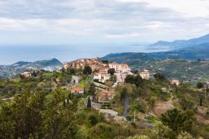 a village on a hill with the ocean in the background at SUNSET with view in Seborga in Seborga