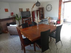 a dining room with a wooden table and chairs at Vue sur L'Ourtizet in Rodome