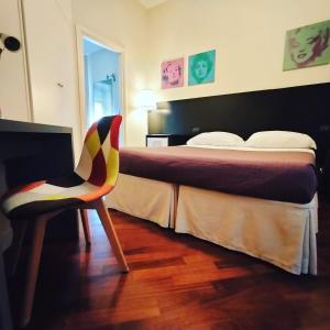 um quarto de hotel com uma cama e uma cadeira em Hotel L' Orto degli Otelli em Frosinone
