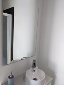 a bathroom with a white sink and a mirror at Chambre double indépendante AVIATEUR au sein du domaine PASSELOUP in Liergues