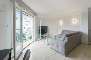 salon z kanapą i telewizorem w obiekcie Appartement de Madrid - Welkeys w Cannes