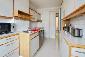kuchnia z białymi urządzeniami i drewnianymi szafkami w obiekcie Appartement de Madrid - Welkeys w Cannes +7 zdjęć