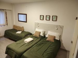 2 camas en una habitación con sábanas verdes en Porteño 7 Hospital Italiano en Buenos Aires