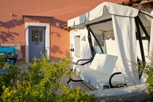 un banc blanc avec un parasol devant une maison dans l'établissement LocriHOUSE-Stylish comfortable home in Galaxidi, à Galaxidi