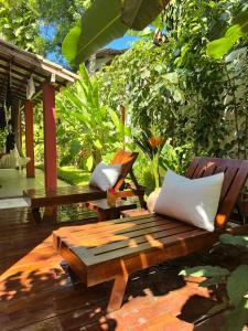 a wooden bench sitting on a deck with pillows at Casa da Beatriz in Trancoso