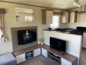 a kitchen with a large flat screen tv in a caravan at PK Holiday Home in Great Yarmouth