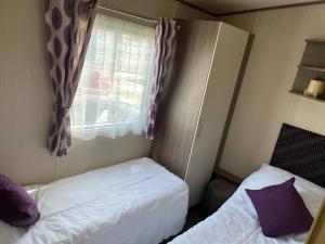een kleine slaapkamer met 2 bedden en een raam bij PK Holiday Home in Great Yarmouth