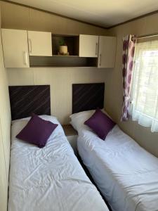 twee bedden in een kleine kamer bij PK Holiday Home in Great Yarmouth