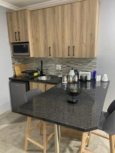 a kitchen with a black counter top and wooden cabinets at The One Kathu in Kathu