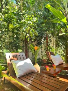 a wooden bench with two pillows on a patio at Casa da Beatriz in Trancoso