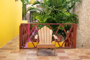 a wooden chair sitting in a room with plants at Art 57 Hotel - Adults Only in Mérida