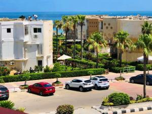 a group of cars parked in a parking lot near the ocean at Maamoura Beach apartment in Alexandria