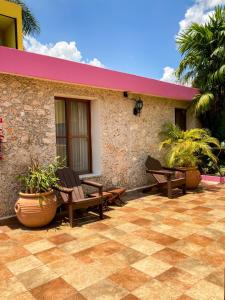 eine Terrasse mit 2 Stühlen und ein Haus in der Unterkunft Art 57 Hotel - Adults Only in Mérida