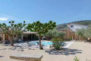 a backyard with a swimming pool and trees and a house at L'Atelier d'André in Beaumes-de-Venise