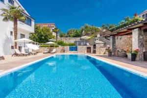 a swimming pool in a villa with aiterraneaniterranean architecture at Apartments Petra Krk in Krk