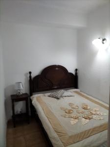 ein Schlafzimmer mit einem Bett mit hölzernem Kopfteil in der Unterkunft Apartamento Maria do Céu Villa Magna in Albufeira