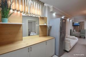 cocina con nevera y espejo en una habitación en Druze Hospitality Mitzpe Hanof en ‘Ein el Asad