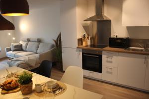 Les hôtes voies في بوالون: مطبخ وغرفة معيشة مع طاولة وأريكة