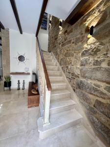 una escalera en una casa con una pared de piedra en Preciosa casa marinera en Carril, en Vilagarcía de Arousa