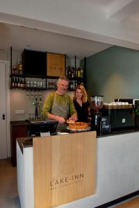 Ein Mann und eine Frau stehen an einer Bar in der Unterkunft The Lake Inn in Nieuwkoop