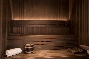 a sauna with a bucket and towels on a shelf at Les Elmes - Hôtel & Spa in Banyuls-sur-Mer