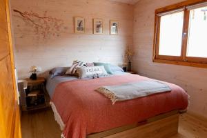 1 dormitorio con 1 cama en una cabaña de madera en Cabaña IkiZen en Barbadillo del Pez