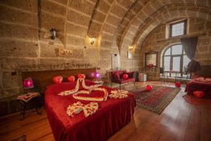 - une chambre en pierre avec un grand lit dans l'établissement Cappadocia Antique Gelveri Cave Hotel, à Guzelyurt