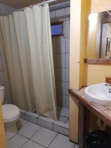 a bathroom with a shower curtain and a sink at Hotel Los Burritos in Puerto Chicama