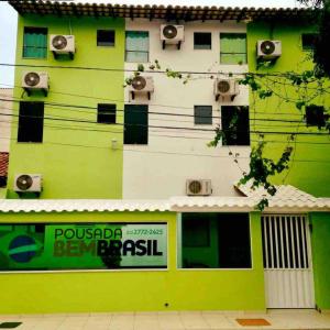 馬卡埃的住宿－Pousada Bem Brasil，一座绿色的白色建筑,上面有扬声器