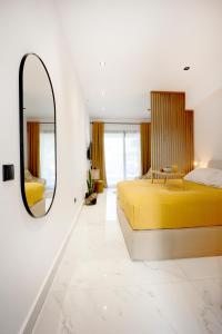 1 dormitorio con cama amarilla y espejo en 06 SUITE, en Kallithea Halkidikis
