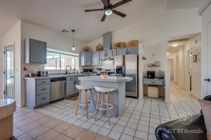 a large kitchen with a counter and stools in it at FRESHWATER FUN - Pet & Family Friendly with Great Location! in Bullhead City