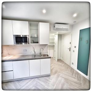 a kitchen with white cabinets and a sink at Le Vallaya Suites & Spa in Menton