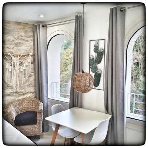 a dining room with a table and chairs and windows at Le Vallaya Suites & Spa in Menton