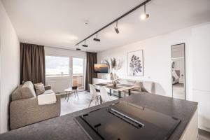 a living room with a couch and a table at Max Studios & Apartments - Zillertal in Schlitters