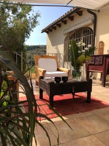 un patio con un banco, una silla y una mesa en Finca la Jarra, en Benitachell