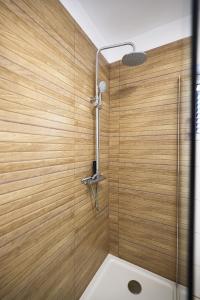 y baño con ducha y pared de madera. en Holiday house Antulov, en Vodice