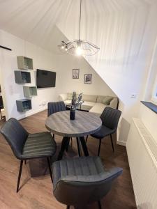 ein Wohnzimmer mit einem Tisch, Stühlen und einem Sofa in der Unterkunft Dyke Appartements in Büsum