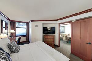 ein Schlafzimmer mit einem großen Bett und ein Wohnzimmer in der Unterkunft Resort at Squaw Creek's 317 & 319 in Olympic Valley
