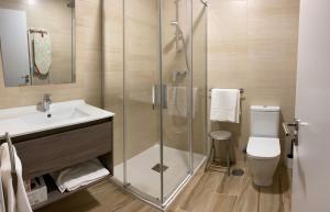 ein Bad mit einer Dusche, einem Waschbecken und einem WC in der Unterkunft Apartamentos Torreones de Cartes in Cartes
