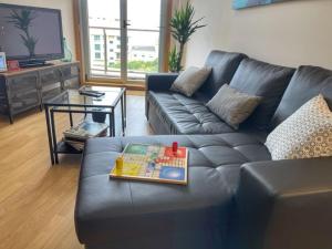 a living room with a black leather couch and a table at Malpica Vistas in Malpica
