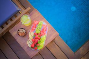 a table with a hot dog with fruit and a drink at 9 Alacati Boutique Hotel in Alaçatı