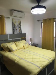a bedroom with a large bed with yellow sheets at Residencial Santa Rosa Apto 8 Section C in Moca +29 photos