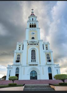 a large white building with a clock tower at Residencial Santa Rosa Apto 8 Section C in Moca