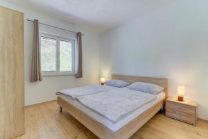 a bedroom with a bed with two lamps on it at Dora Apartment-Adults Only in Senj