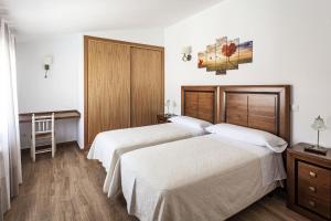 a hotel room with two beds and a table at Casa Rural La Fontanita in El Real de San Vicente