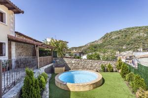 un patio trasero con piscina y una casa en Casa Rural La Fontanita, en El Real de San Vicente